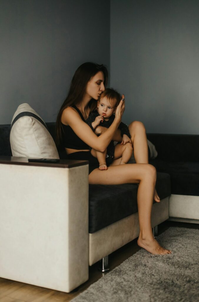 a woman sitting on a couch with a baby
