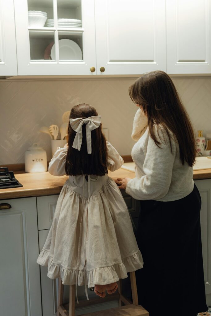 A woman and a little girl standing in a kitchen